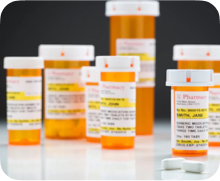Multiple prescription mediction bottles lined up on a counter