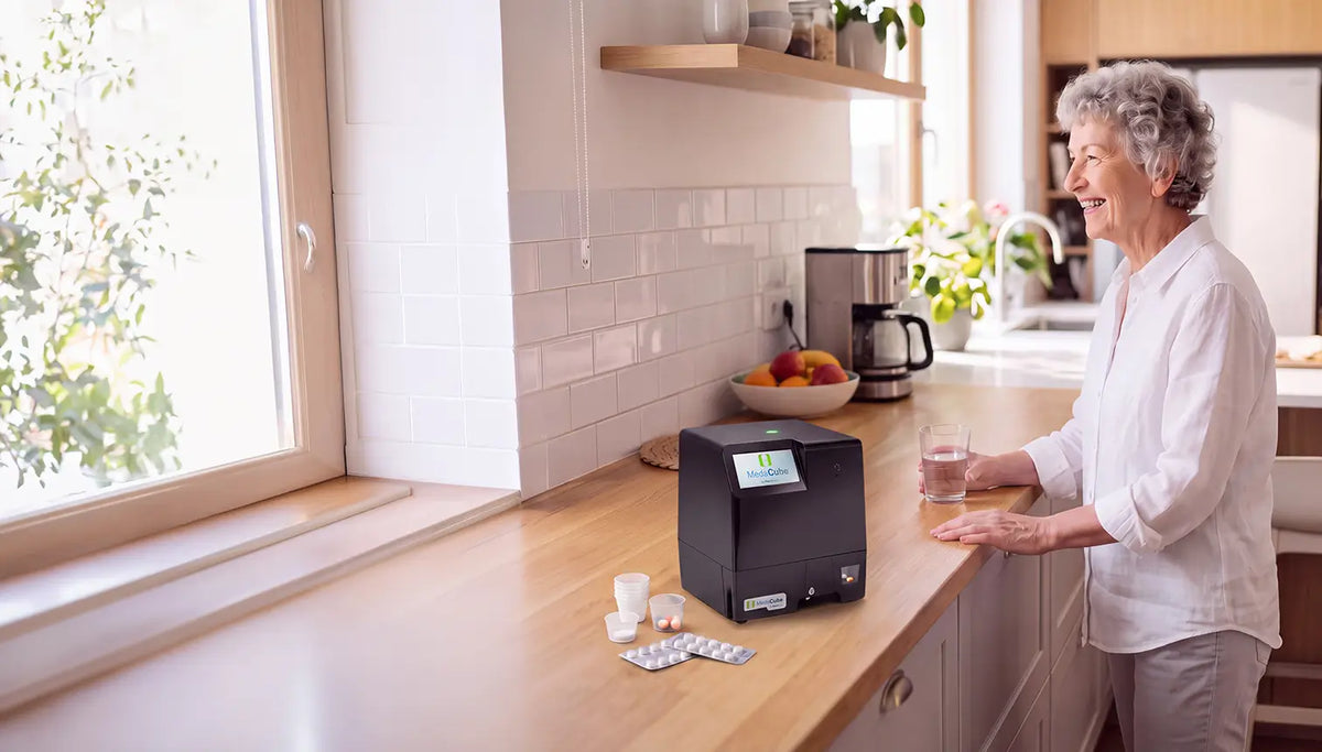 Older Senior Lady is taking her medications next to the kitchen countertop Medacube Automatic Pill Dispenser