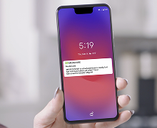 Hand holding a phone with a text message notification from the MedaCube