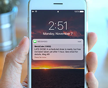 Hand holding a phone showing a text message notification fom the Medacube 
