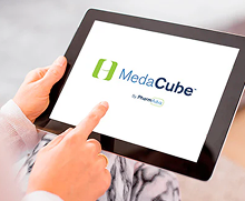 Tablet held in one hand showing the MedaCube Logo on screen, another hand is pointing at the screen.