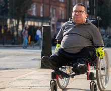 Man in while chair outside